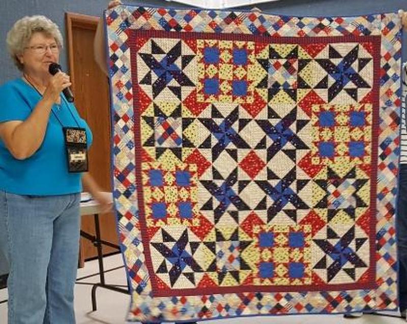 Connie M shows a Quilt of Valor that she is donating